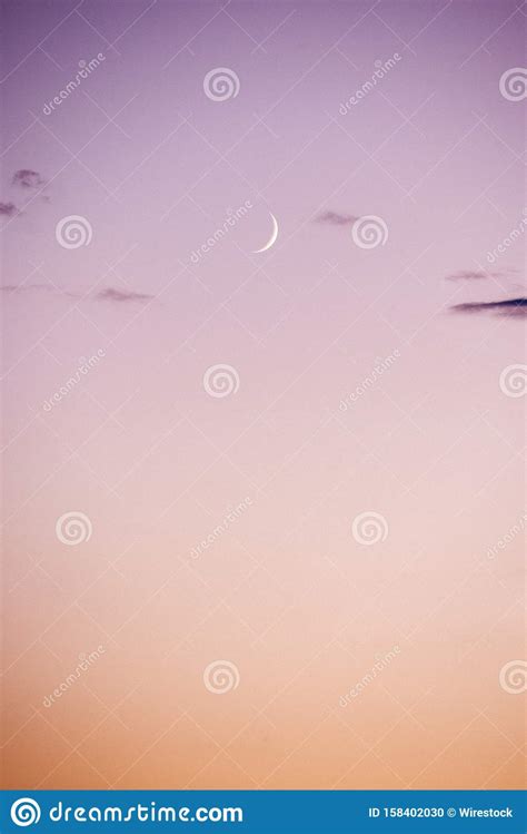 Vertical Shot Of The Crescent Moon In The Pink Purple Sky Stock Photo