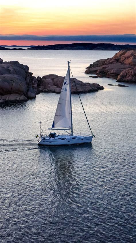 Download Wallpaper 1440x2560 Boat Sail Sea Stones Sunset Horizon
