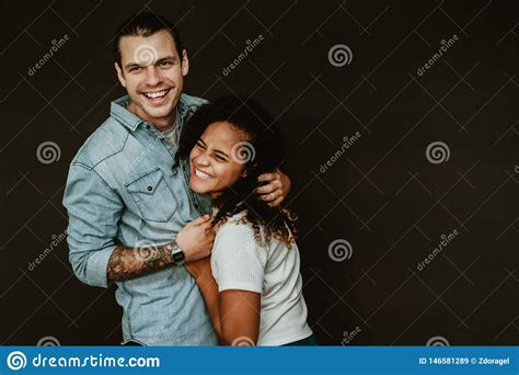 Portrait Of Happy Excited Mixed Race Young Couple In Love Hugging And
