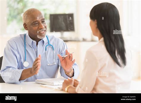 Black Doctor And Patient Talking In Office Stock Photo Alamy