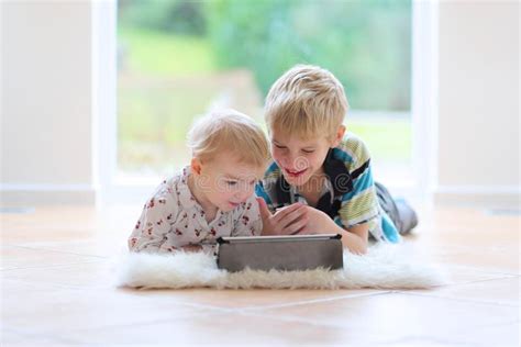 Il Fratello E La Sorella Che Giocano Con Acqua Annaffiano Nel Giardino Immagine Stock Immagine