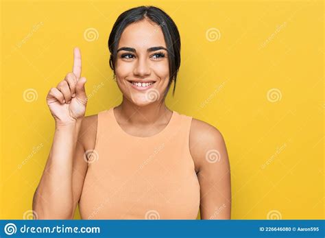 Young Brunette Woman Wearing Casual Clothes Showing And Pointing Up With Finger Number One While
