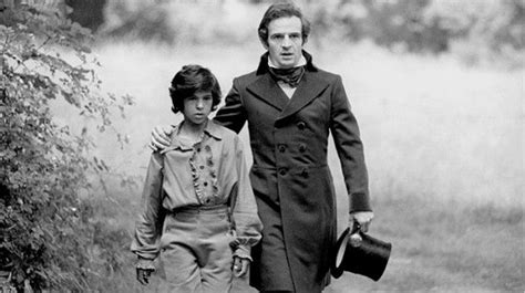 An Old Black And White Photo Of Two People Walking Down A Path In The Woods