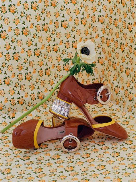 A Pair Of Shoes Sitting On Top Of A Floral Wallpaper Covered Floor Next