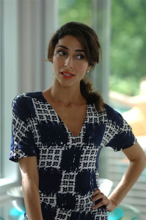 A Woman Standing In Front Of A Glass Table With Her Hands On Her Hips And Looking At The Camera