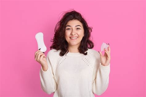 premium photo cheerful woman holding tampon and hygiene pad in both hands having period