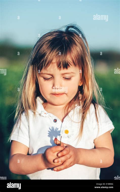Baby Girl Holding Little Flower Stock Photo Alamy