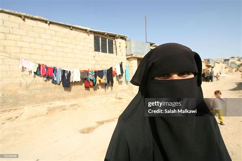 A Palestinian Refugee Woman Looks On As She Stands Beside Her Home On