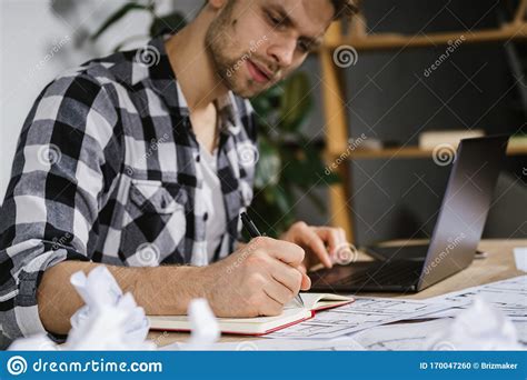 Young Adult Architect Working With Blueprints In Workspace Office Stock