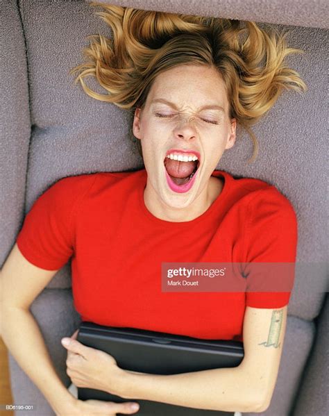 Woman Lying On Sofa Hugging Laptop Computer Mouth Wide Open Photo