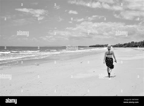 Women Walking Alone On A Remote Tropical Beach Black And White Stock
