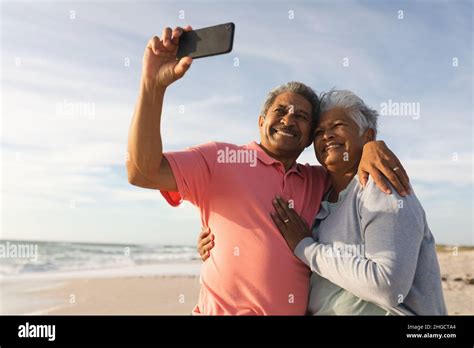 Smiling Senior Biracial Man Taking Selfie Through Smartphone With Arm