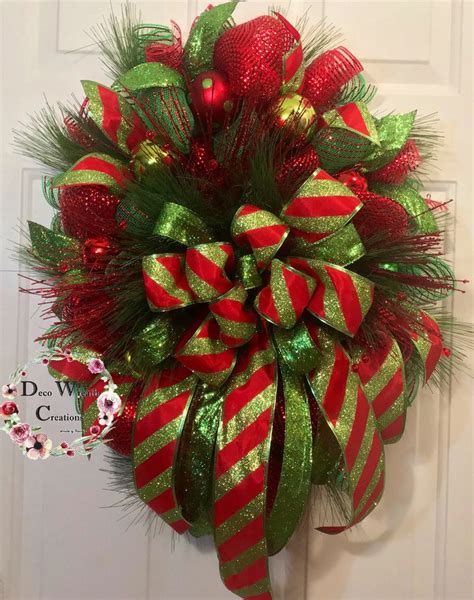 A Red And Green Christmas Wreath Hanging On The Front Door