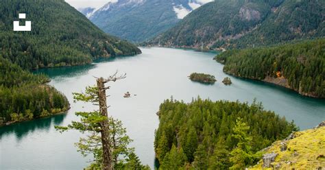 A Large Body Of Water Surrounded By Mountains Photo Free Water Image