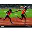 Track & Field Runners In A Relay Race Passing Baton Stock Photo 