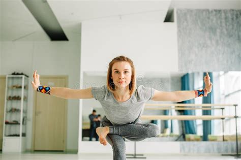 Woman Doing Balancing Exercises During A Yoga Workout In Well Lit Gym
