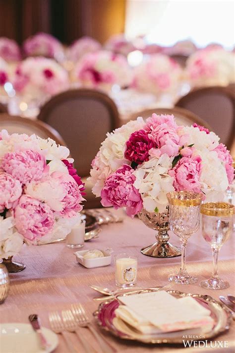 Pink And White Flowers Sit In Vases On A Table With Candles Lit Up
