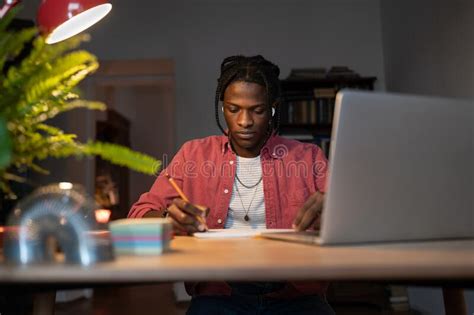 Hardworking Young African Guy Student Writing Notes While Watching