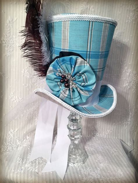 A Blue Top Hat With A Feather On It And Some White Paper In The Background