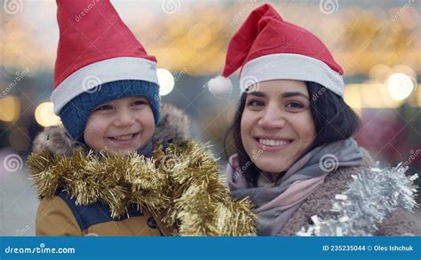 Close Up Happy Middle Eastern Mother And Son In Christmas Hats Rubbing