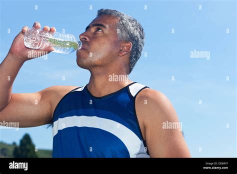 Mixed Race Man Drinking Water Bottle Stock Photo Alamy