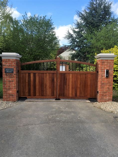 A Driveway Gate With Brick Pillars And Gates