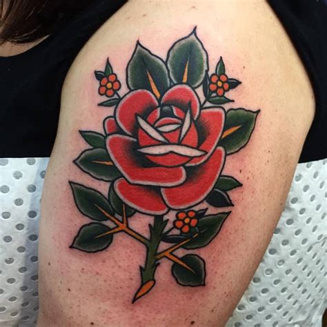 Traditional Red Rose With Green Leaves Tattoo On The Thigh