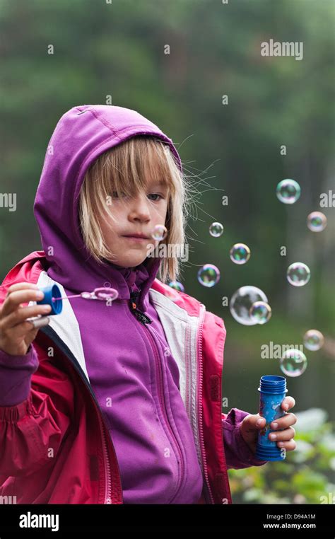 Girl Blowing Bubbles Outdoors Stock Photo Alamy