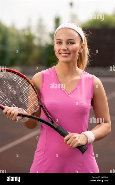 Pretty Young Blonde Female Tennis Player In Pink Dress Holding Racket