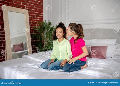 Two Girls Sitting On The Bed And Talking Stock Photo Image Of