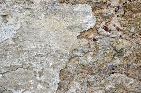 Texture Of Old Stone Wall With Collapsed Plaster Background Of Shabby Building Surface