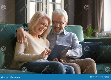 Happy Senior Old Couple Sit On Sofa Using Digital Tablet Stock Image Image Of People