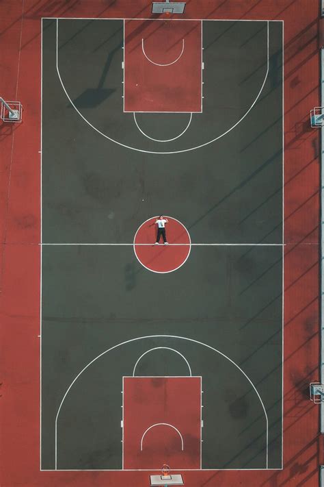 Person Lying In The Middle Of Basketball Court Photo Free Basketball
