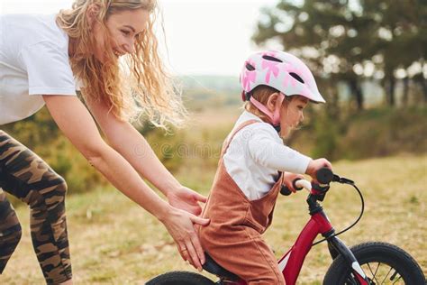 Mother In White Shirt Teaching Daughter How To Ride Bicycle Outdoors Stock Image Image Of