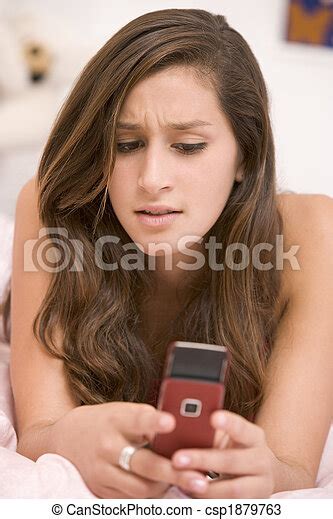 Teenage Girl Lying On Her Bed Using Mobile Phone Canstock