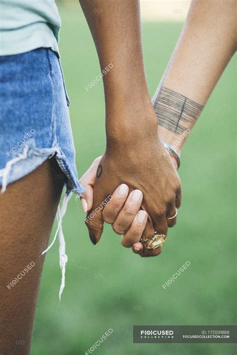 Close-up of Two women holding hands in a park — selective ...
