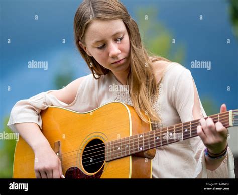 Outdoor Portrait Of Teenage Girl Playing Acoustic Guitar Stock Photo