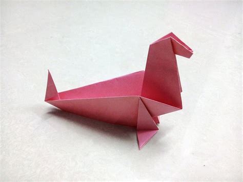 A Pink Origami Duck Sitting On Top Of A Table