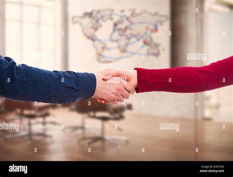 man and woman handshake over office indoor background with world map business partnership and