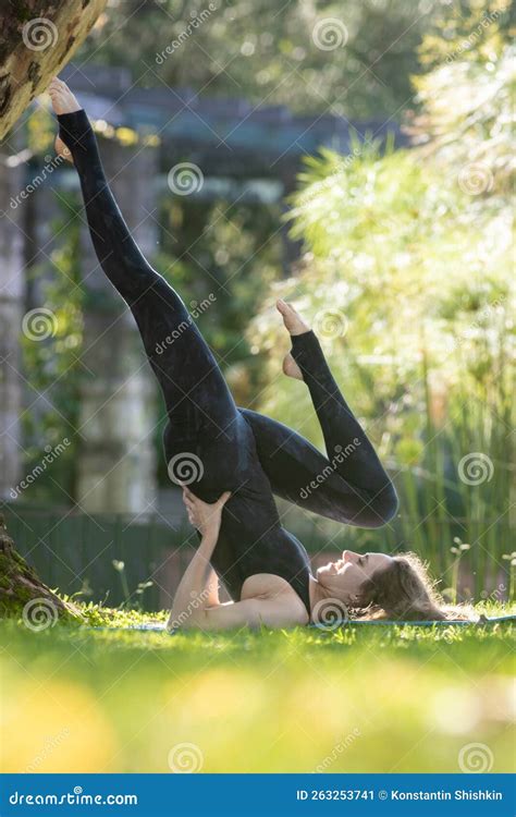 A Woman Does Yoga In The Park Lying On Her Back And Raising Her Legs Up Stock Image Image Of