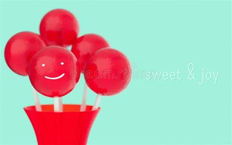 Red Balls Of Lollipops On Stick Vase With Hand Drawn Smile Face In Red