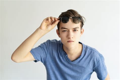 Free Photo Serious Concentrated Young Man Holding Sunglasses