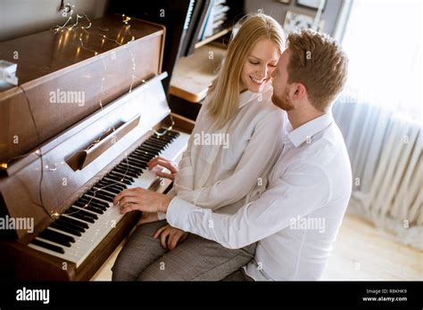 Loving Young Couple Playing Piano In The Room At Home Stock Photo Alamy