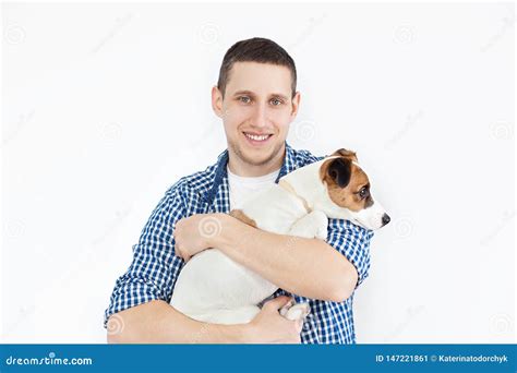 A Smiling Handsome Man Holding A Purebred Dog On A White Background