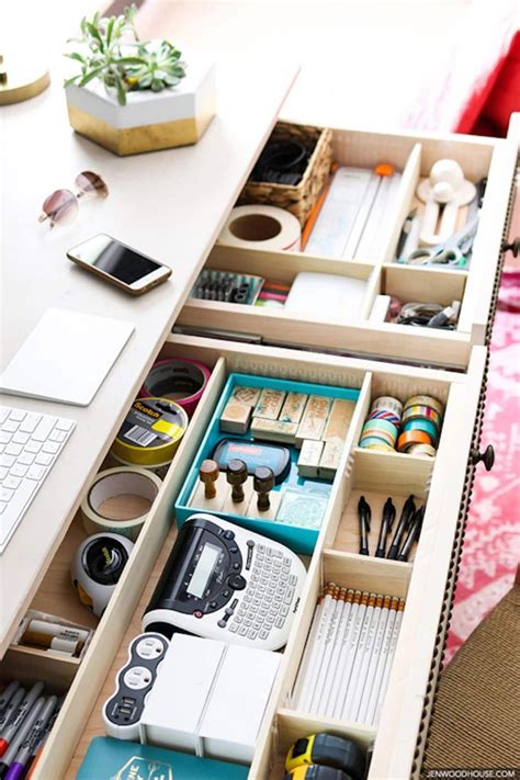 An Open Drawer With Various Items In It And A Laptop On The Desk Next To It