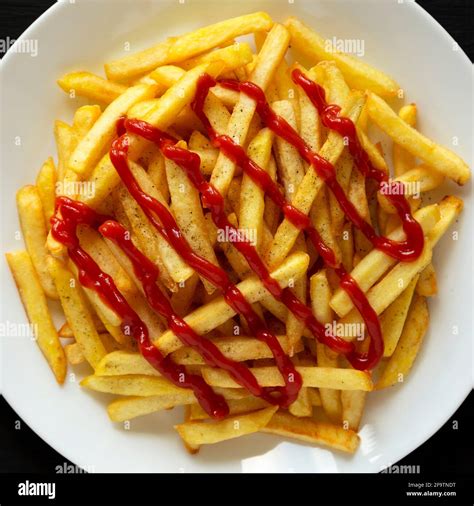 Homemade French Fries With Ketchup Salt And Pepper On A White Plate On