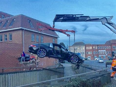 Porsche Crashes Through Car Park Wall And Nosedives On To Path