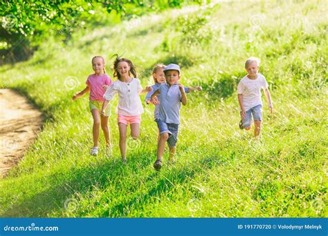 Kids Children Running On Meadow In Summer S Sunlight Stock Photo