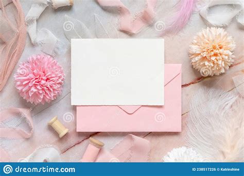 Card And Pink Envelope Near Pastel Flowers Silk Ribbons And Feathers