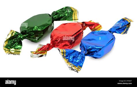 Three Chocolate Candies With Wrappers Of Different Colors On A White